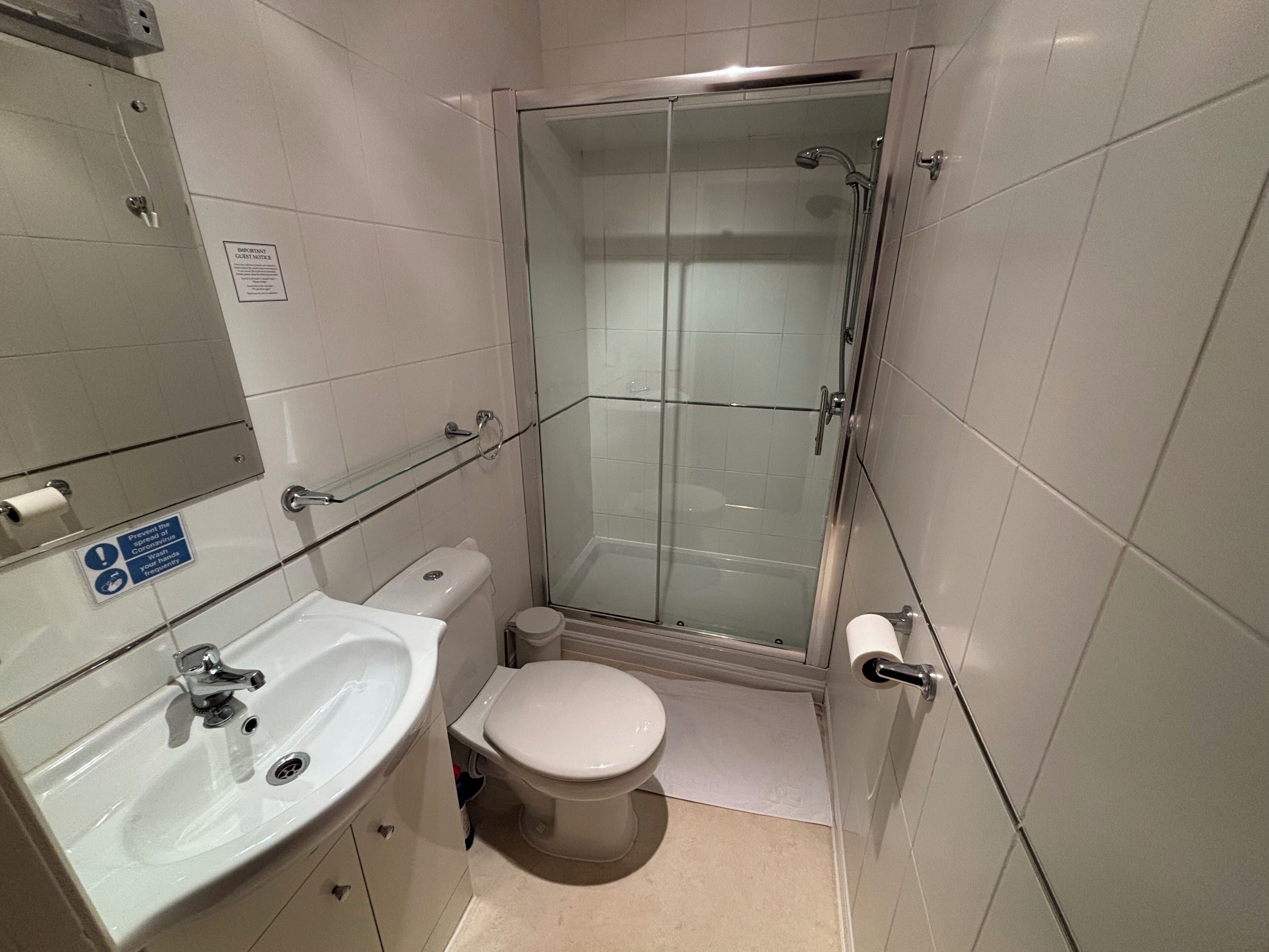 Ein kleines Badezimmer mit Toilette, Waschbecken und Duschkabine.