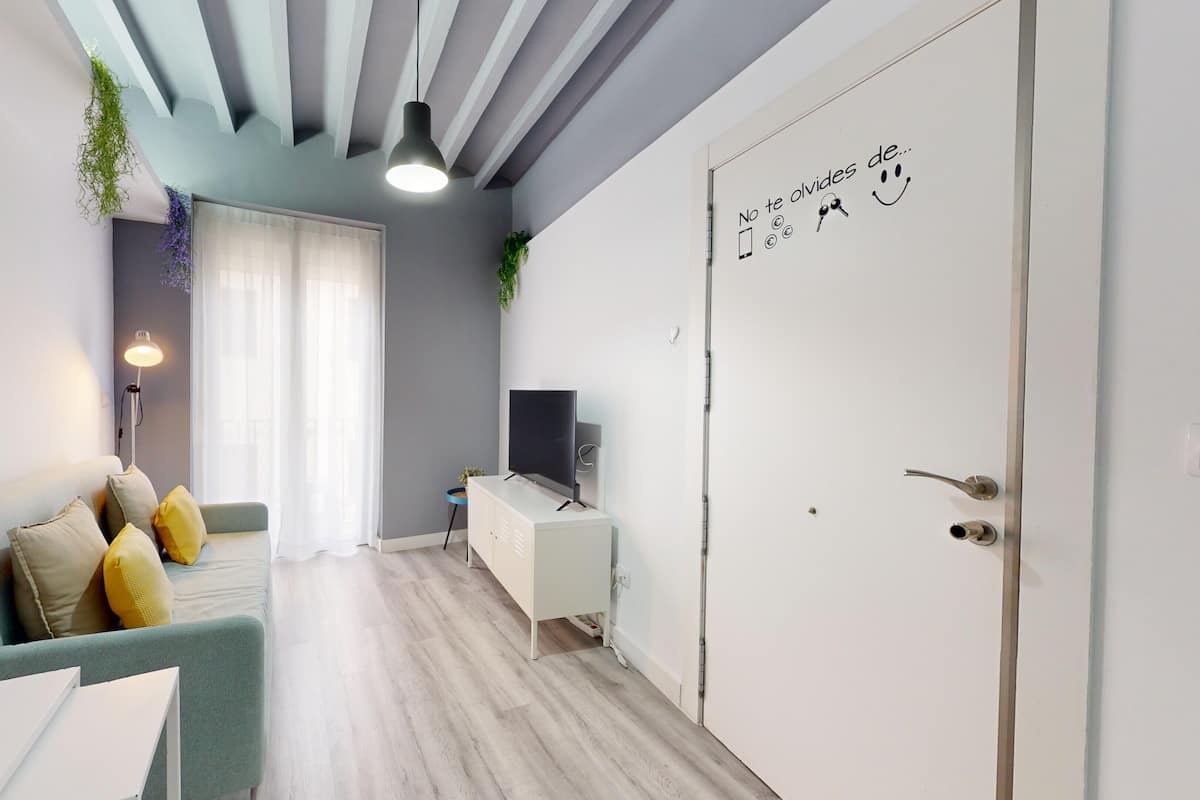 Een moderne woonkamer met een bank, een televisie en een deur met een motiverende quote.