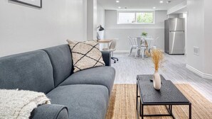 A modern living room with a grey sofa, a black coffee table, and a decorative vase.