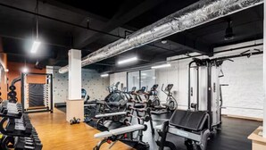 A gym with various exercise equipment, including treadmills, elliptical machines, and weightlifting stations. - 1Bedroom | Downtown | Gym & Coworking space + Wifi (Cincinnati)