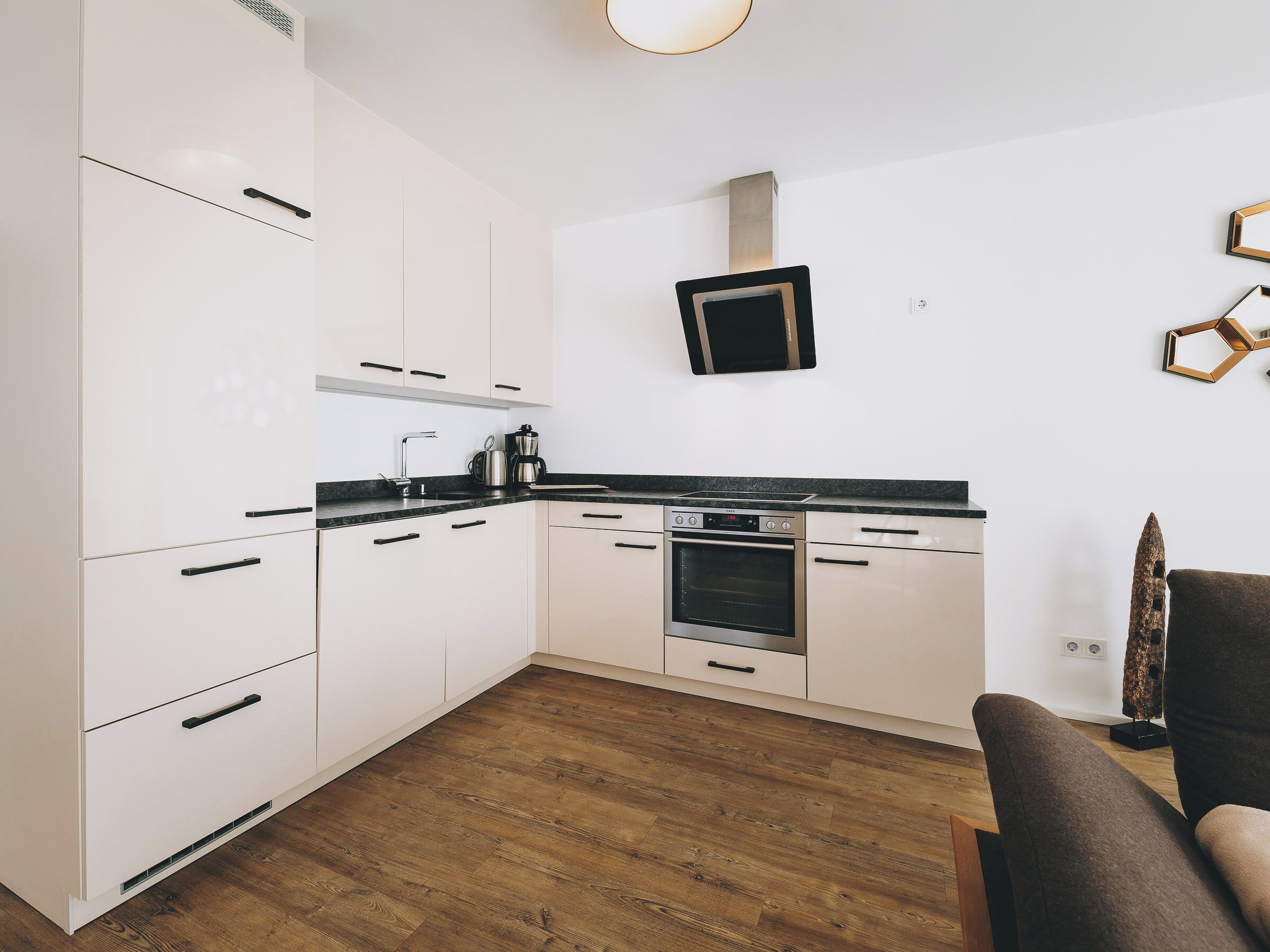 A modern kitchen with white cabinets, a built-in oven, and a microwave.