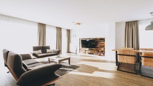 Una sala de estar moderna con un sofá, una mesa de centro y una pared con televisor.