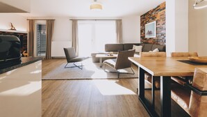 Una sala de estar moderna con comedor, chimenea y un amplio ventanal con cortinas.