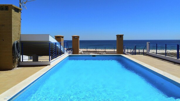 A rectangular swimming pool with clear blue water, surrounded by a tiled deck and a blue railing. - Apartment, Lagos - Formerly TUI Ferienhaus (Lagos)