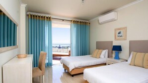 A hotel room with two beds, a desk, a chair, and a view of the sea. - Apartment, Lagos - Formerly TUI Ferienhaus (Lagos)