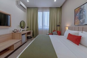 Relax in a stylish room with a large bed, desk, and TV, plus a refrigerator and coffee maker for your convenience.