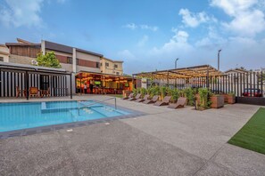 Relax by the pool surrounded by lounge chairs and a covered seating area.