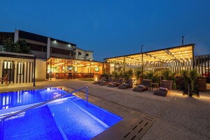 A swimming pool with lounge chairs and a bar area.