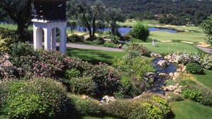A golf course with a gazebo, lush greenery, and a lake in the background. - Apartment in Pegomas With Private Pool (Pegomas)