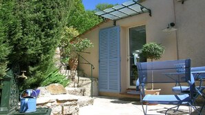 A patio area with outdoor furniture, a stone wall, and a potted plant. - Apartment in Pegomas With Private Pool (Pegomas)