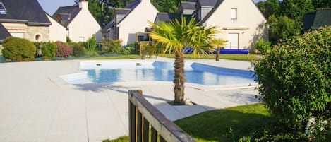 Ein Wohngebiet mit Schwimmbad, Häusern mit Satteldach und Holzzaun.