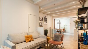 A modern living room with a sofa, armchair, coffee table, and a bookshelf. - Luxury Apartment with spacious living room (Amsterdam)