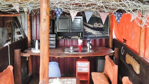 Una zona de bar con sillas de madera, una barra y un televisor.