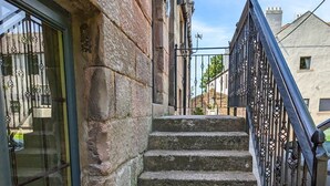 A stone staircase with metal railings leading to a building entrance. - One Bedroom Cottage in the heart of Beadnell (Beadnell)