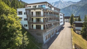 A multi-story hotel with balconies, set against a mountainous backdrop. - Wifi, 100m from ski slopes, sauna, hammam, balcony, parking, ski locker, 87m², Peisey-Vallandry (Mâcot-la-Plagne)