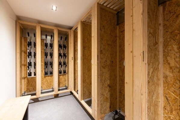 A room with exposed wooden framing, a grey floor, and a wooden table.