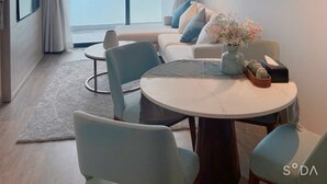 Ein modernes Hotelzimmer mit einem großen Balkon, einem runden Esstisch und einer Sofagarnitur.