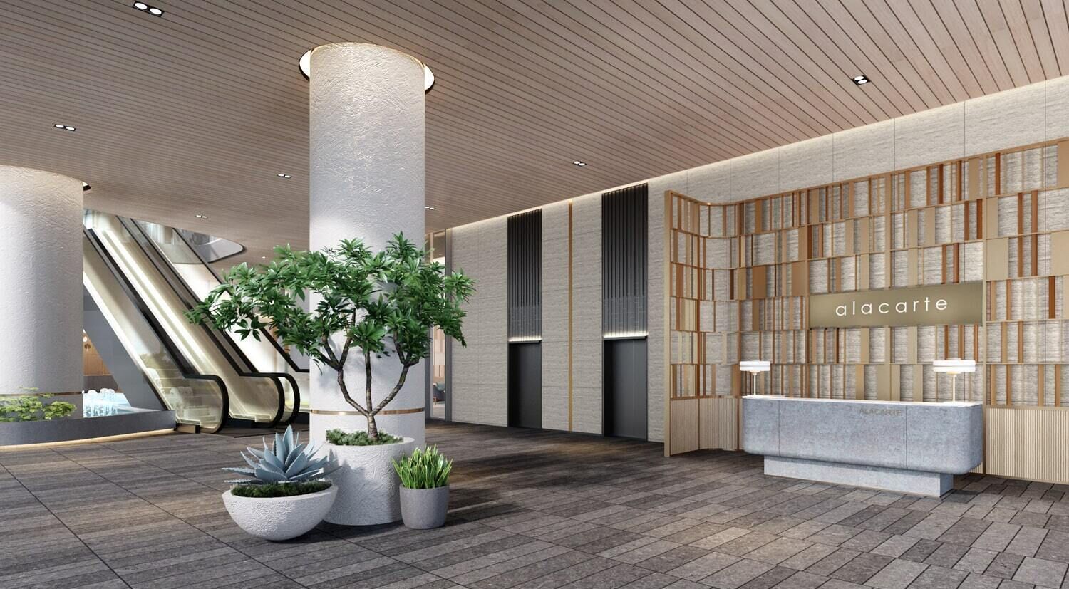 Un vestíbulo moderno con mostrador de recepción, una planta grande y una escalera mecánica.