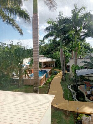 A resort with a swimming pool, palm trees, and a covered outdoor seating area. - Azcapri Villa-Boutique & Spa (Cancun)