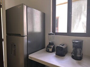 A kitchen with a refrigerator, a blender, a toaster, and a coffee maker on the counter. - Azcapri Villa-Boutique & Spa (Cancun)