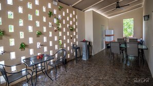 A spacious indoor area with a stone floor, a wall with small windows, and several tables and chairs. - Azcapri Villa-Boutique & Spa (Cancun)
