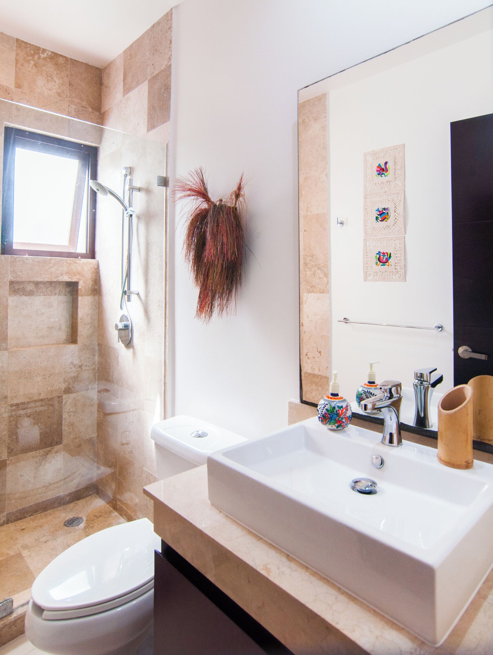 A modern bathroom with a large sink, a toilet, and a shower.