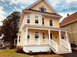 A two-story house with a front porch and a staircase leading to the entrance. - Heritage Harbour 2 Bed 2 Bath Close to Waterfront (Charlottetown)