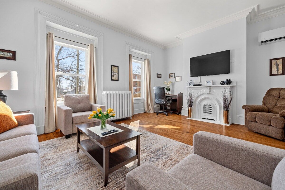 A living room with a fireplace, a television mounted on the wall, and a comfortable seating area with sofas and a coffee table.