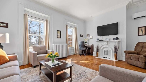 Amplia sala de estar con chimenea, televisor montado en la pared y una zona de estar cómoda con sofás y una mesa de centro.