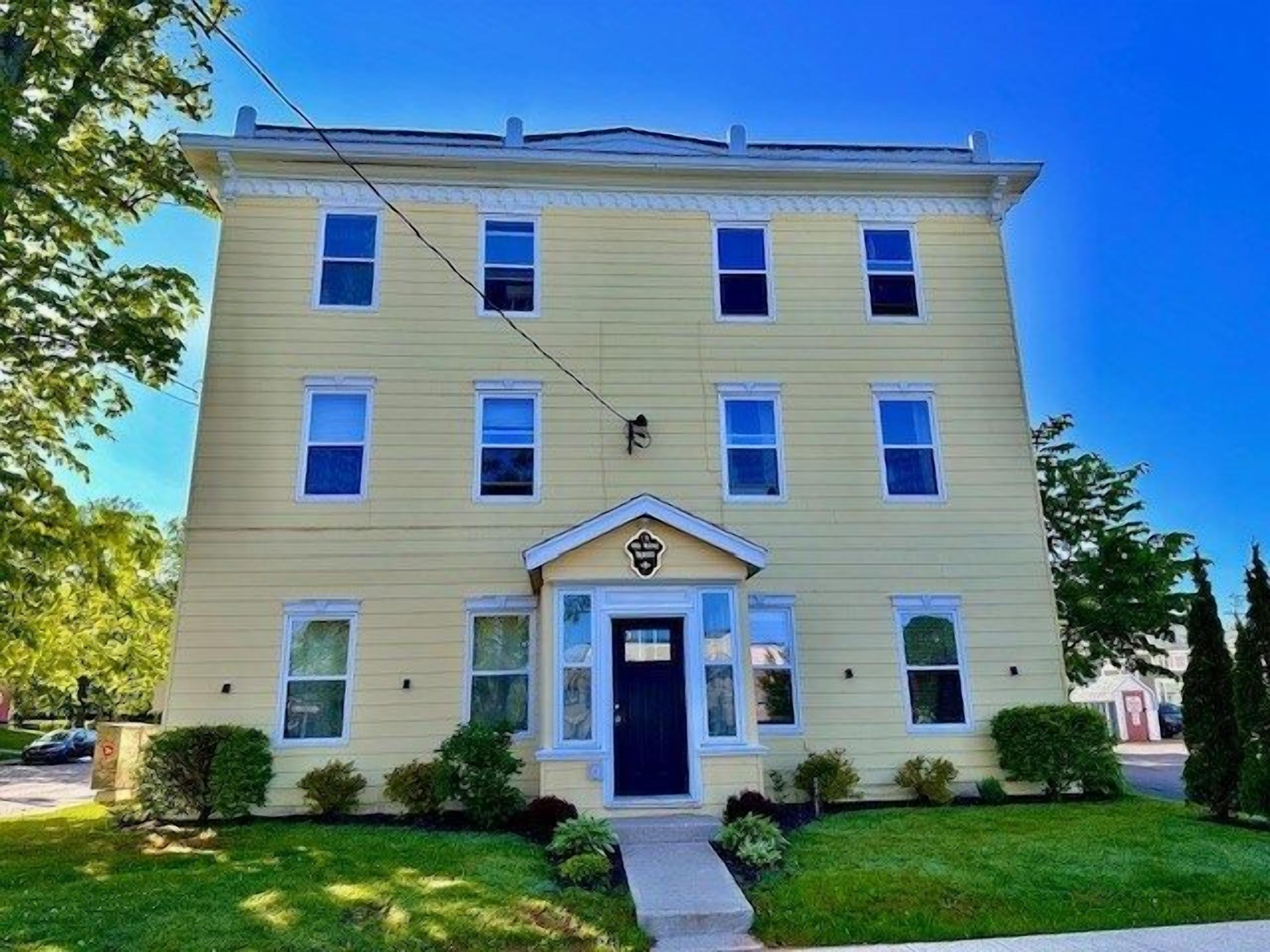 A two-story building with a central entrance and a small porch.