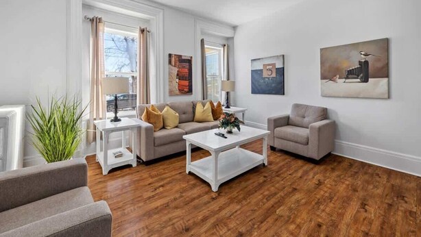 Un salon comprenant un canapé, des fauteuils, une table basse et des œuvres d’art accrochées aux murs.