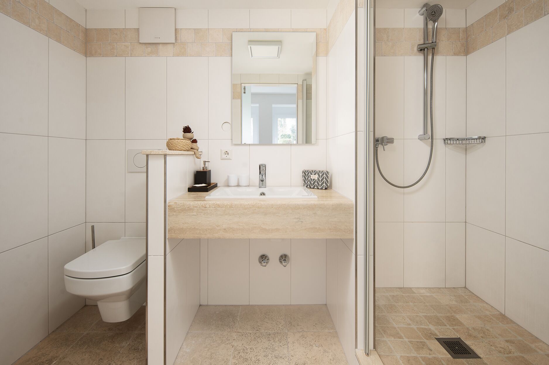 Un baño moderno con inodoro, lavamanos y ducha.