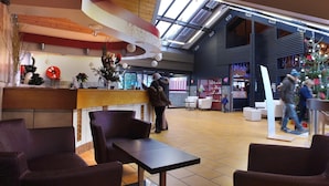 Eine großzügige Lobby mit Empfangsbereich, Sitzgelegenheiten und einem Weihnachtsbaum.
