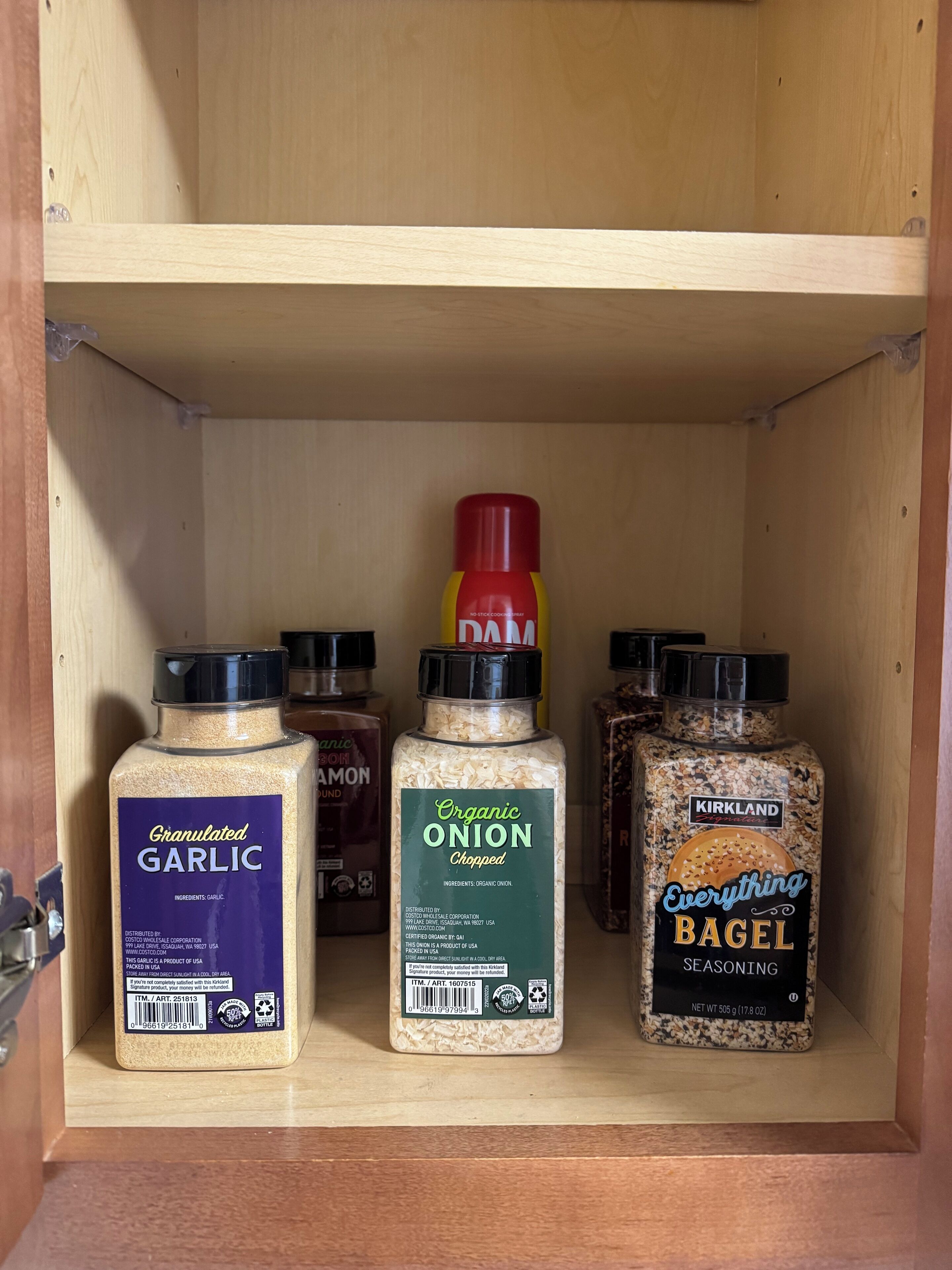 Et træskab med tre krydderiglas: Granuleret hvidløg, økologisk hakket løg og Kirkland Signature Everything Bagel Seasoning.