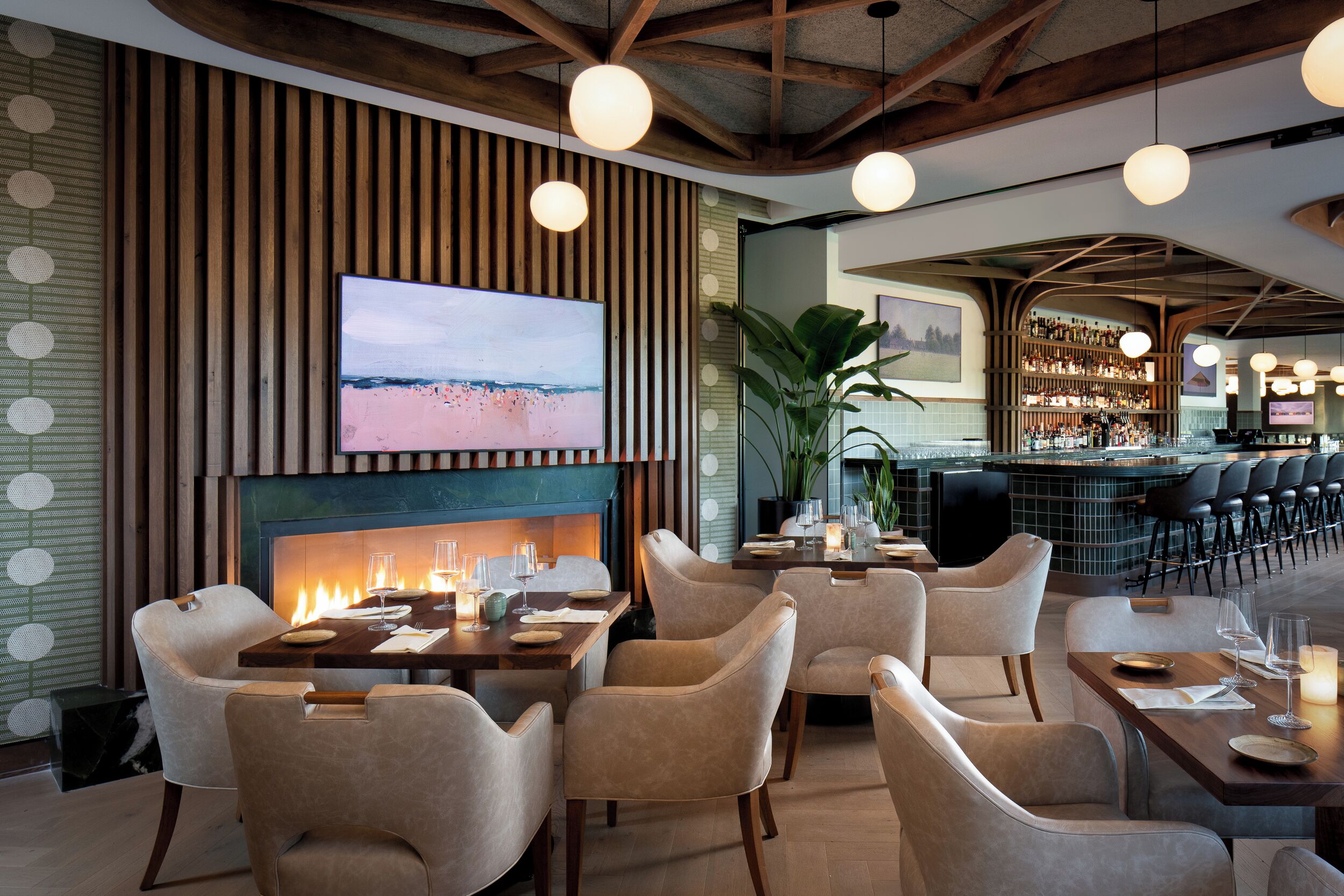 Un restaurant doté d’une cheminée, de tables et d’un bar.