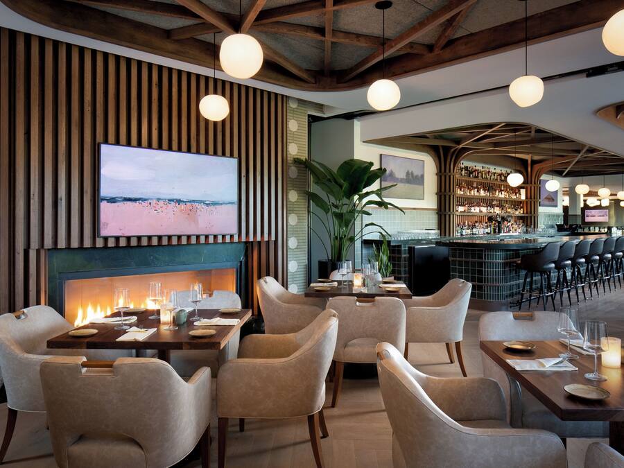 Un restaurante con chimenea, asientos y una zona de bar.