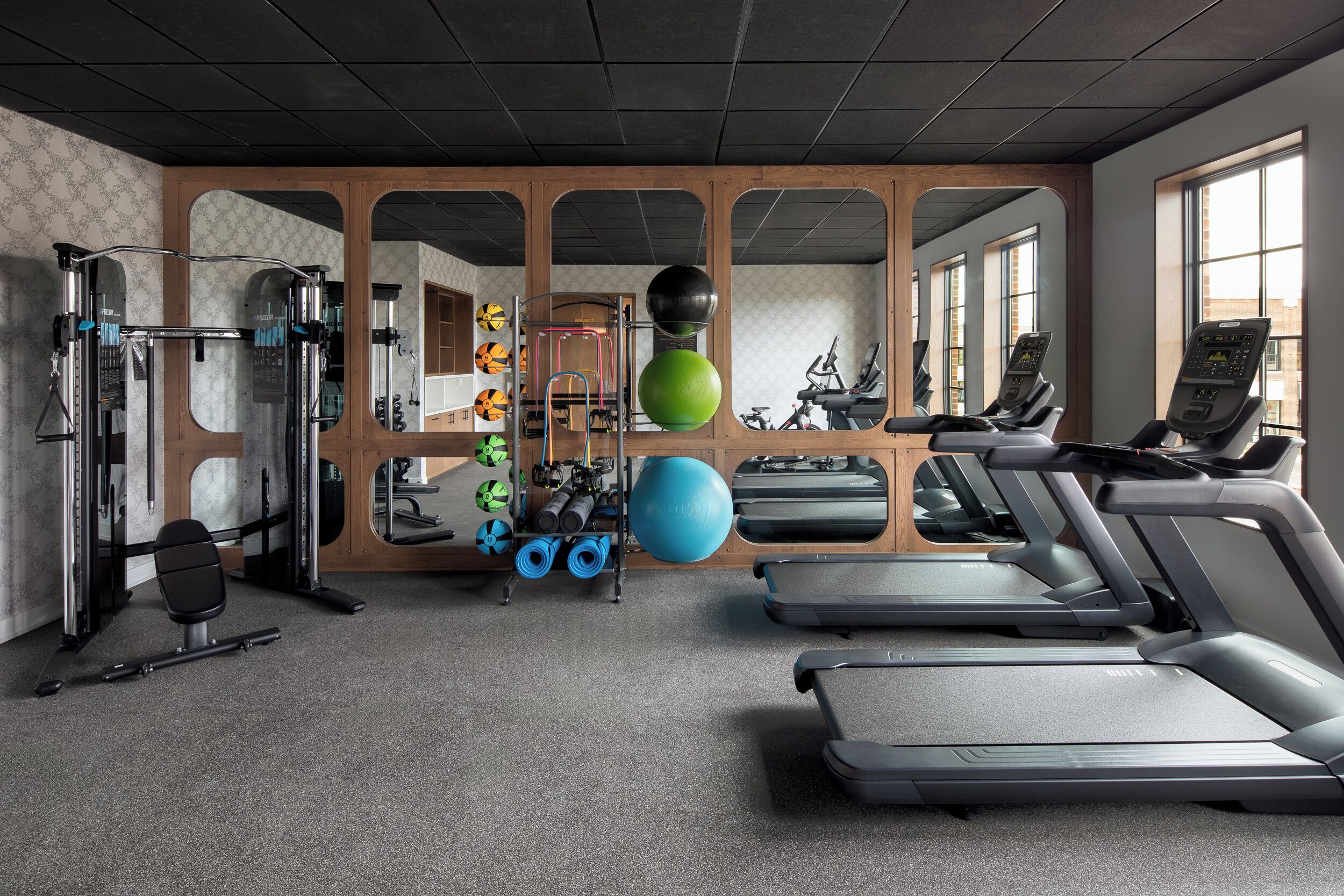 Un gimnasio con cintas de correr, pelotas de ejercicio y máquinas de pesas.