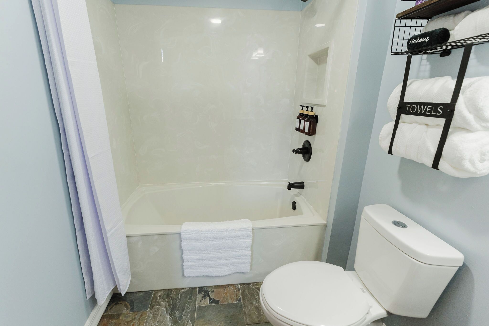 Une salle de bain équipée d’une baignoire, de toilettes et d’un porte-serviettes avec des serviettes.