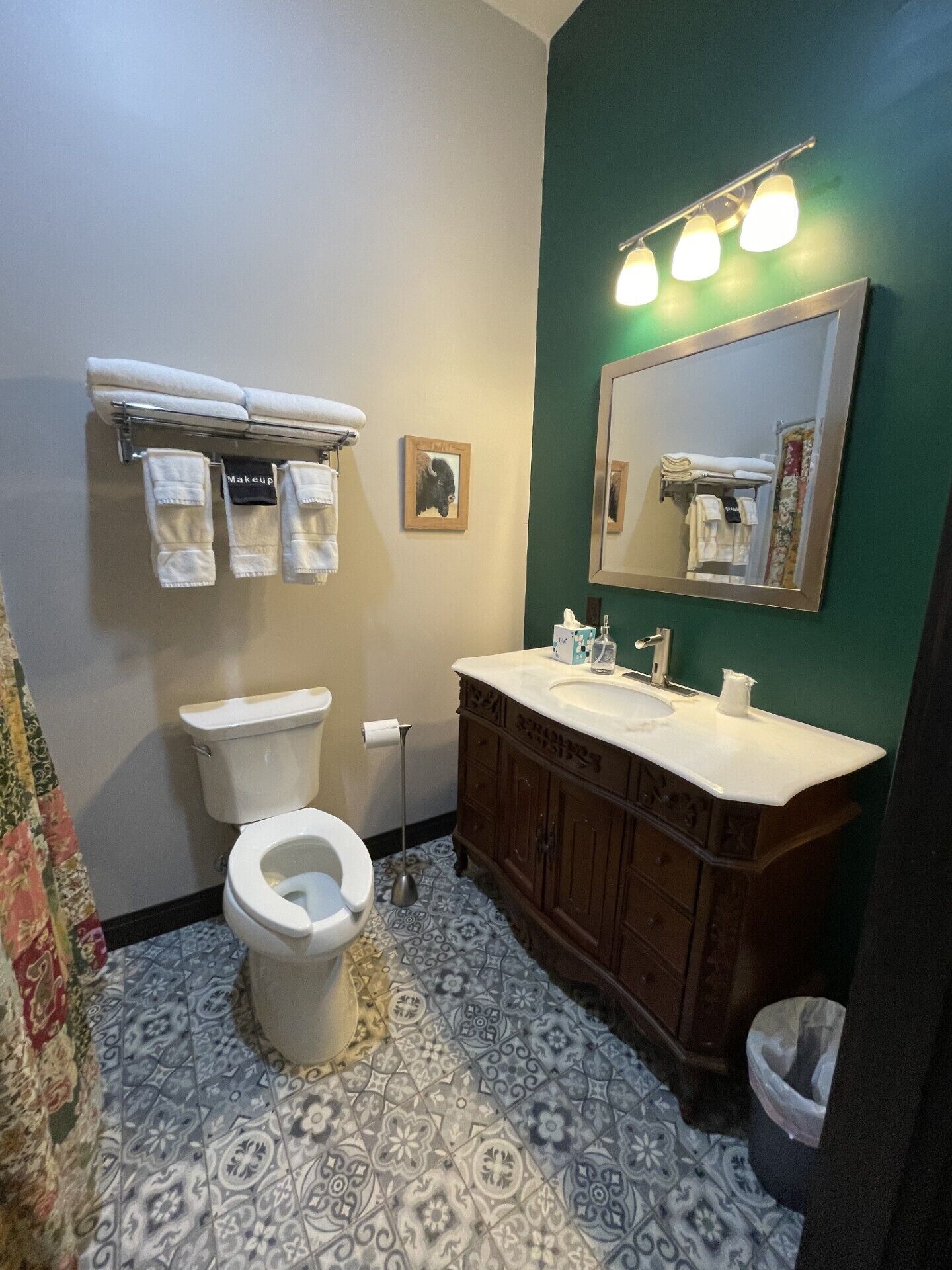 Une salle de bain comprenant des toilettes, un lavabo, un meuble-lavabo et un porte-serviettes.