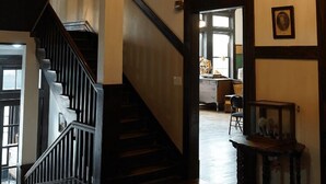 Una gran escalera con candelabro, paredes de madera y un cuadro enmarcado.