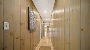 Un pasillo con paneles de madera en las paredes y piso de color claro.
