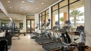Ein Fitnessstudio mit Laufbändern, Crosstrainern und Krafttrainingsgeräten.