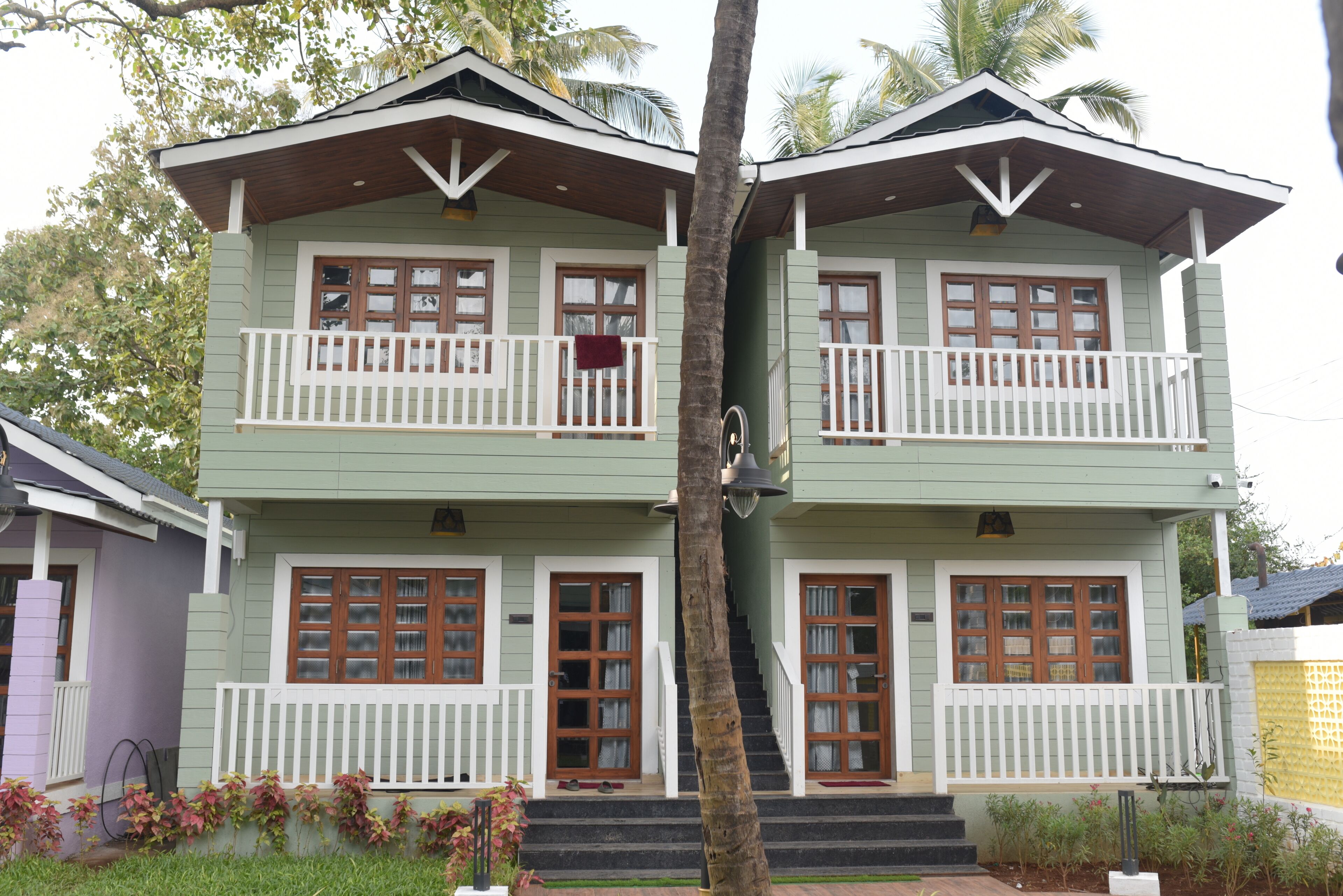 A two-story house with a balcony, a staircase, and a front porch.