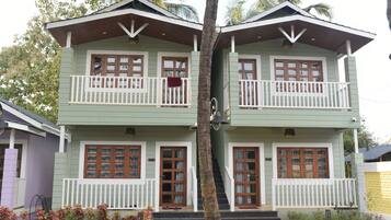 A two-story house with a balcony, a staircase, and a front porch.