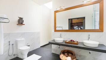 Un bagno moderno con due lavabi, un ampio specchio e un lavabo in rame.