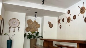 A modern interior with a wooden bench, a potted plant, and decorative wall art. - Recanto do Porto Hotel (Porto Seguro)