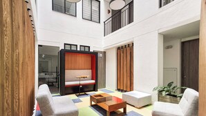 A modern indoor space with a seating area featuring a sofa and armchairs, a coffee table, and a colorful rug. - Beautiful 5 star Loft - near Iserra 100 Bogota (Bogotá)
