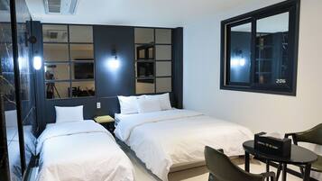 A hotel room with two beds, a desk, a chair, a mirror, and a window with the number 206.