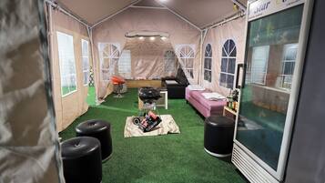 Una habitación con carpa, una kitchenette, un sofá y un ventanal grande.