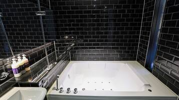 Une salle de bain moderne avec une grande baignoire, un lavabo et un miroir.